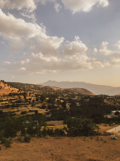 Free Breathtaking view of a vast, mountainous landscape with scattered clouds and a warm, earthy tone. Stock Photo