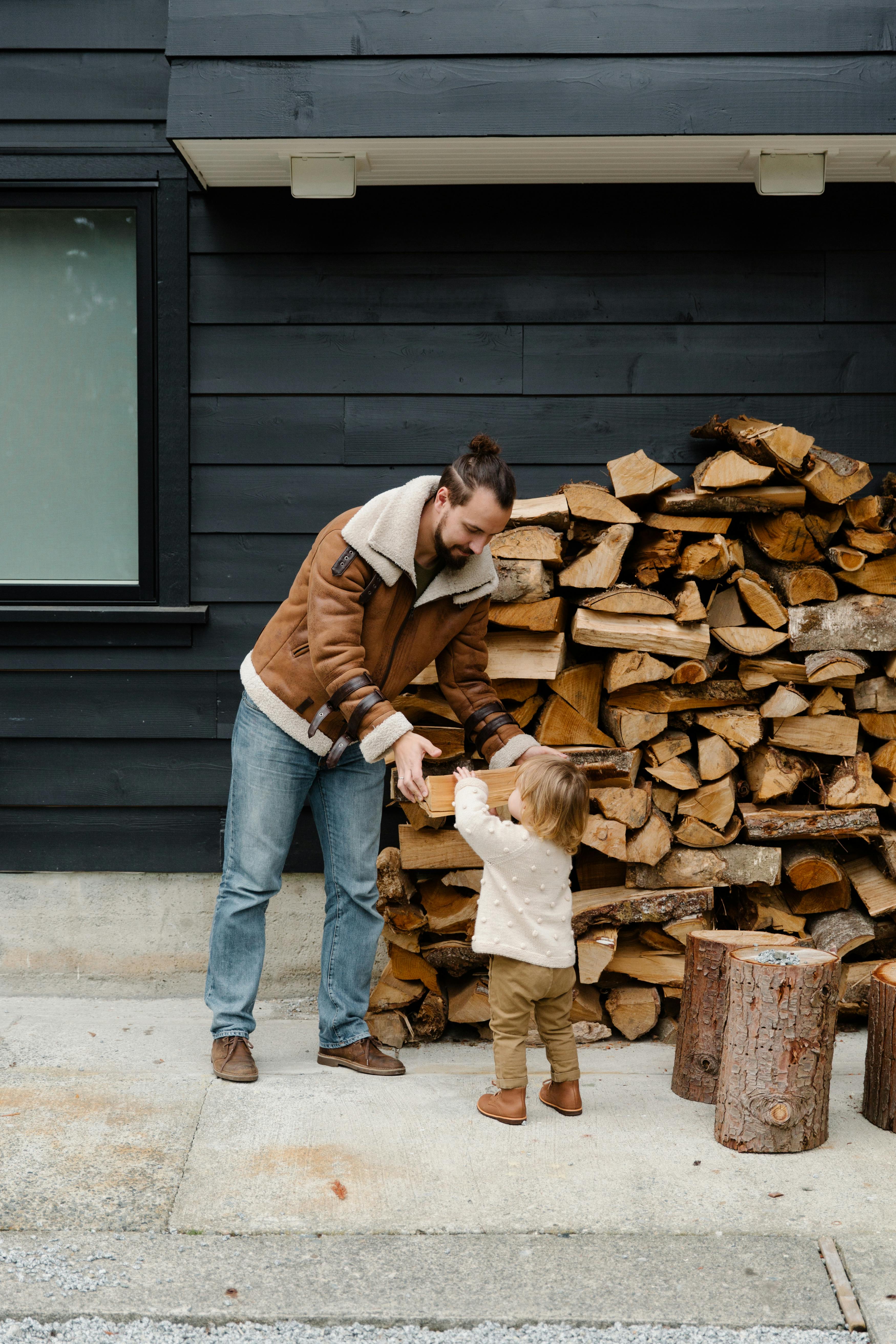 Little girl helping father with firewood · Free Stock Photo