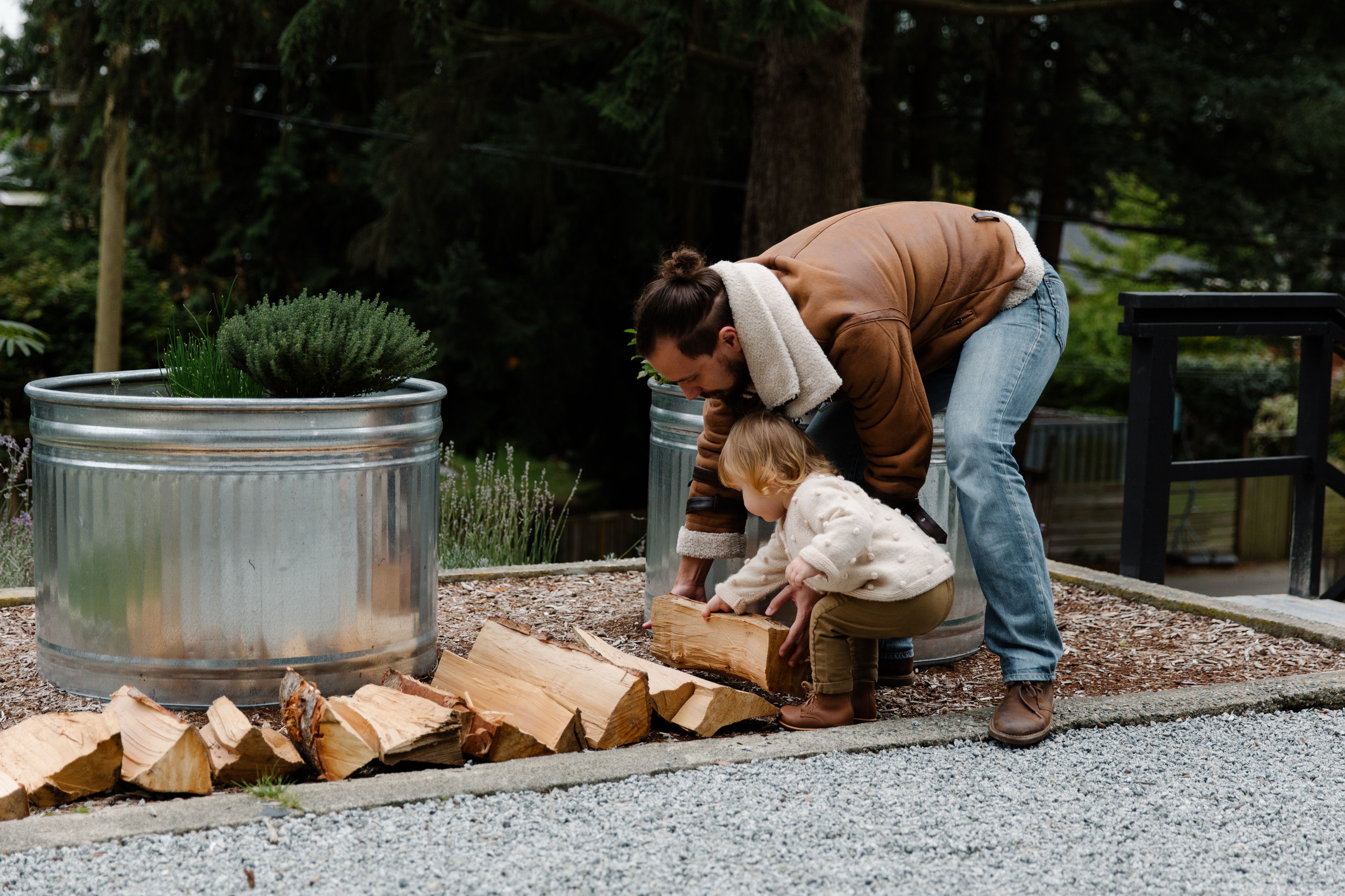 Cheerful father and kid with firewood near house · Free Stock Photo