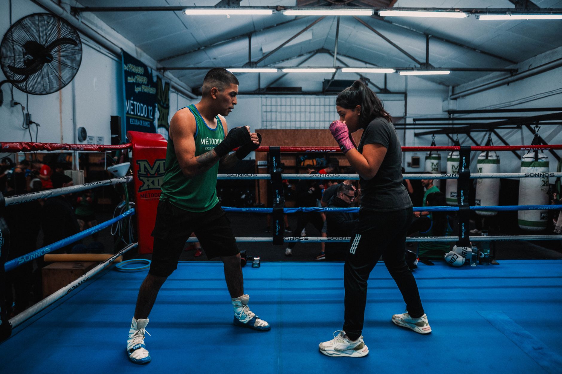 Two athletes sparring in a Buenos Aires boxing gym. Indoor sports training.