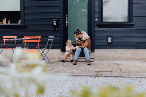 Free Father and child sitting near door in backyard Stock Photo
