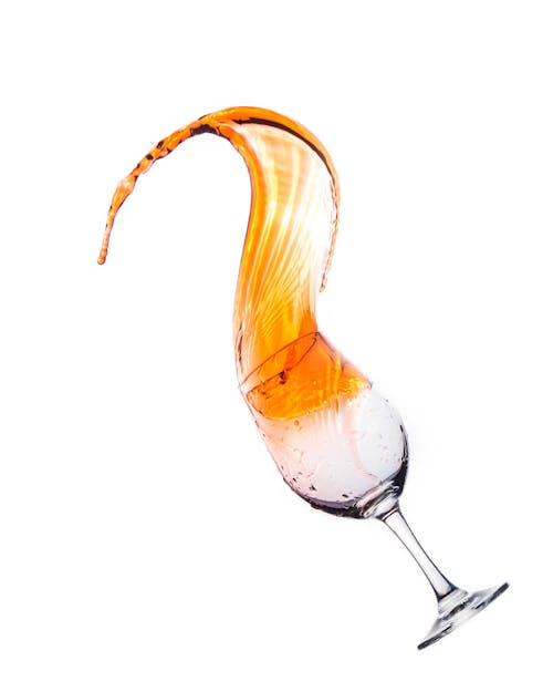Orange Liquid Splashing from a Wine Glass