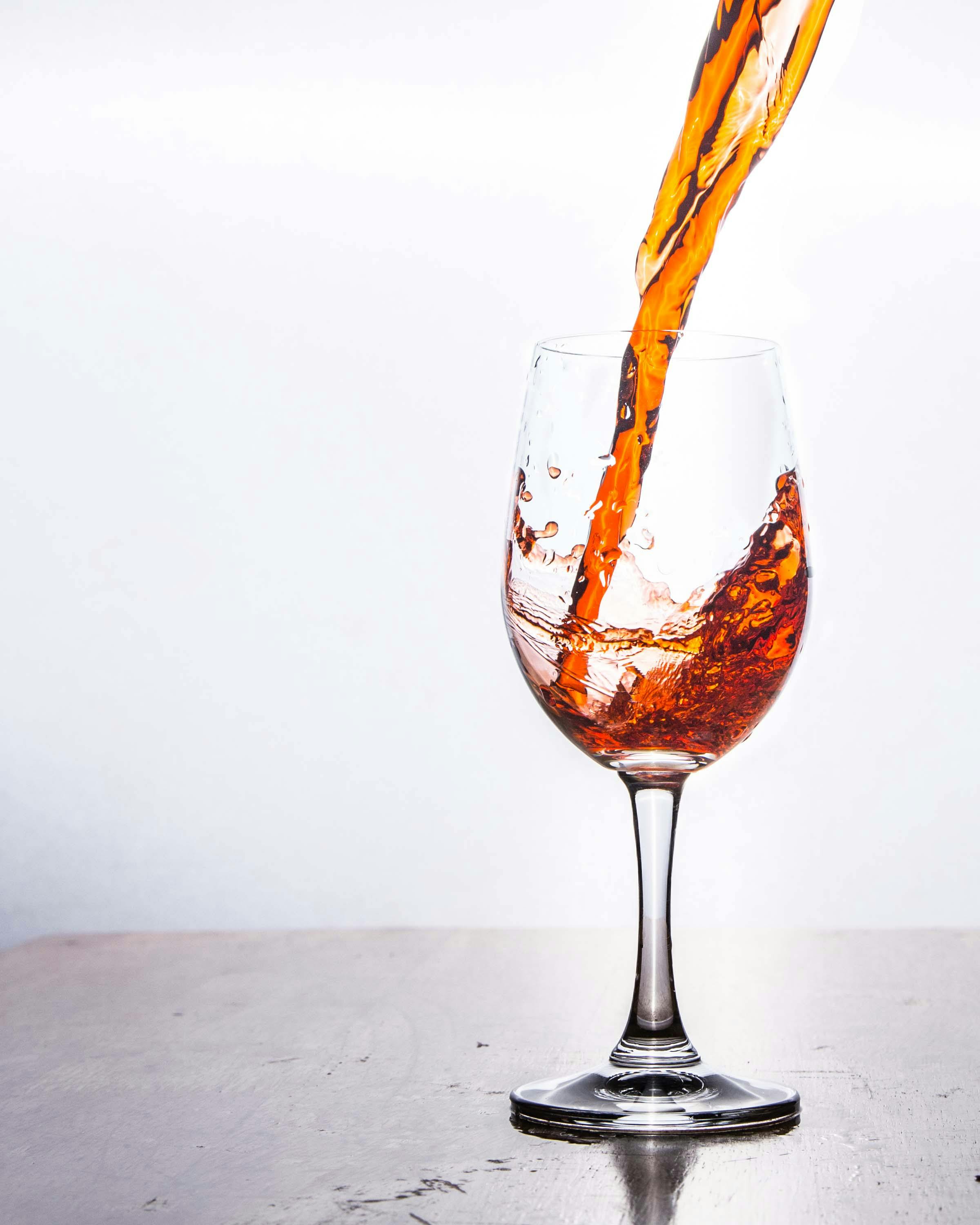 Pouring Liquor on a Wine Glass · Free Stock Photo