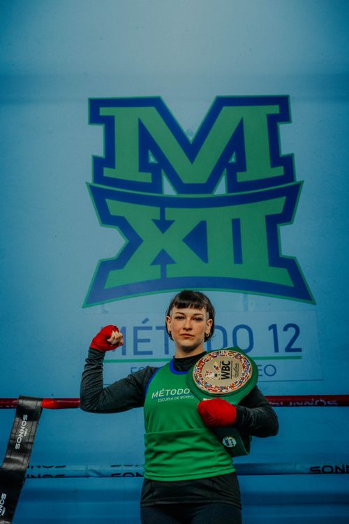 Free Confident female boxer holding championship belt in Buenos Aires gym setting. Stock Photo