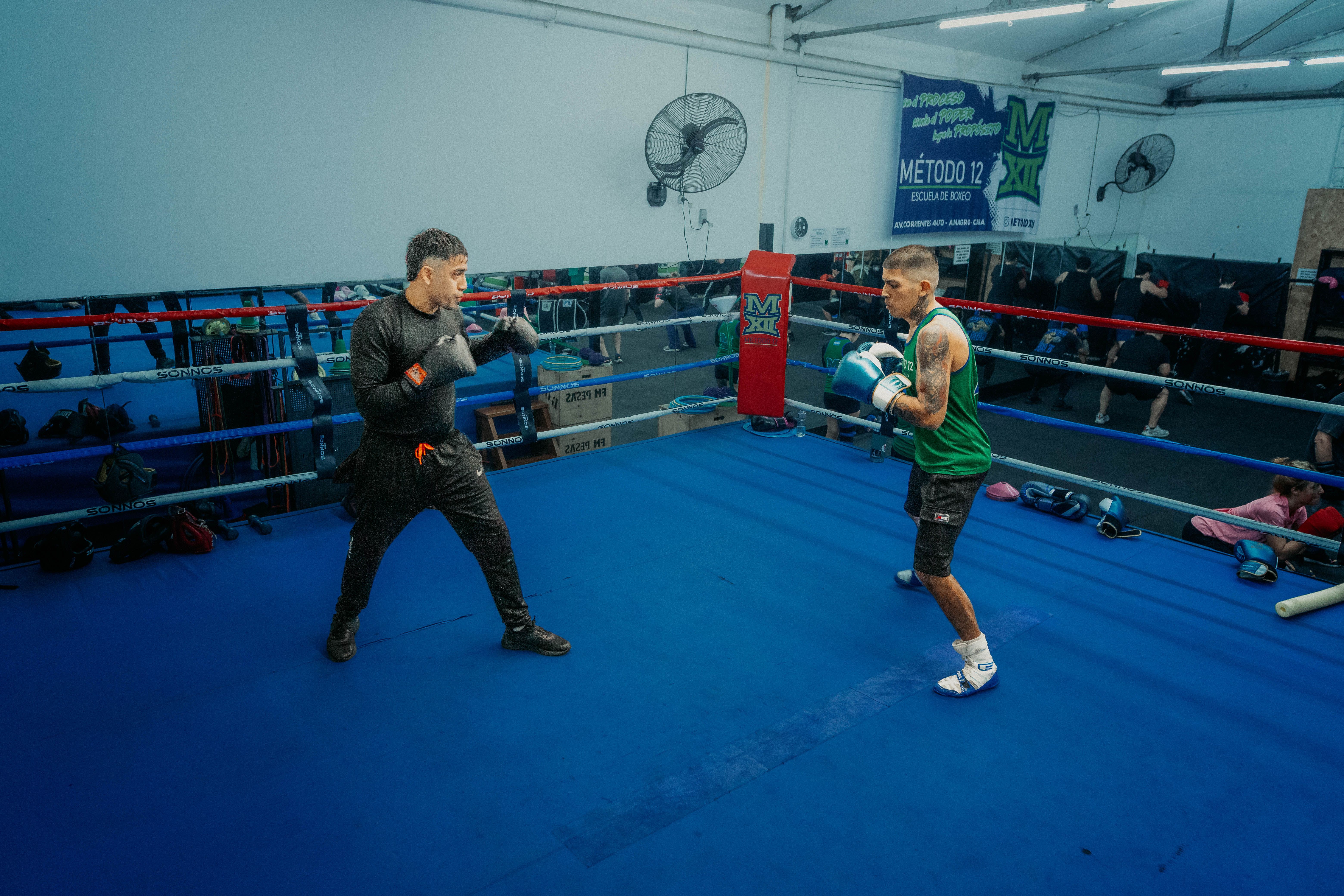 Two boxers sparring in a Buenos Aires boxing gym, showcasing intense training and focus.