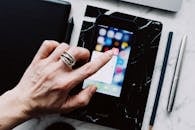 Faceless person using smartphone while working with gadgets at home