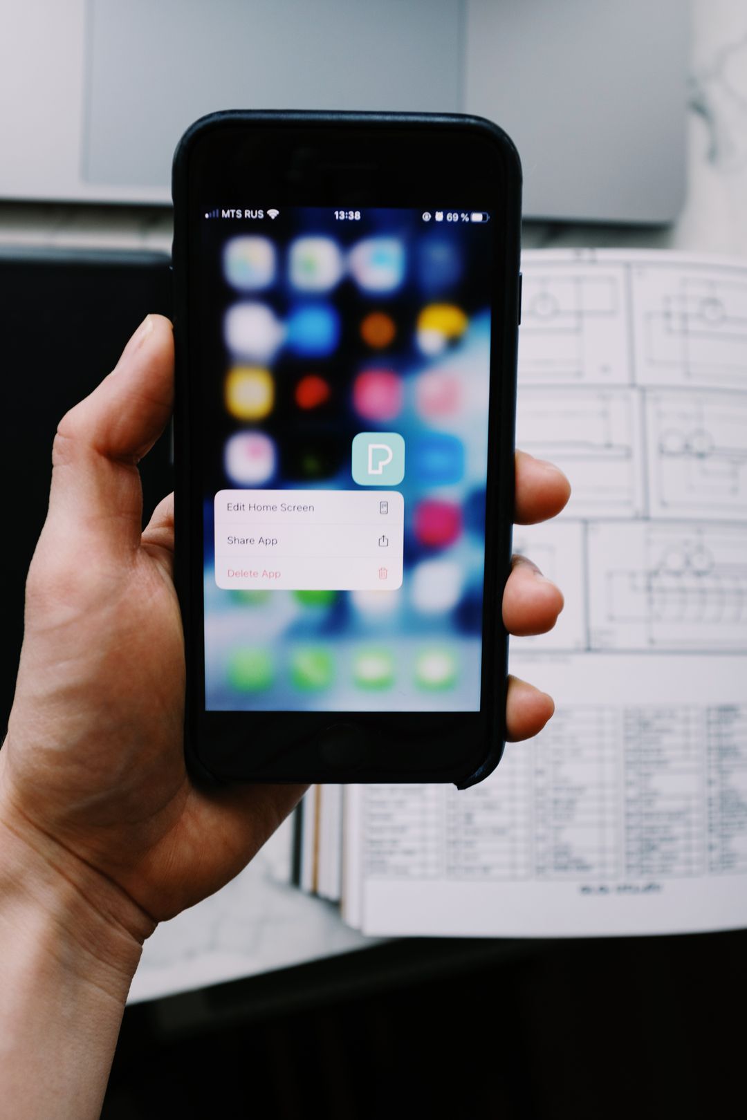 Hand holding a smartphone showing an app interface