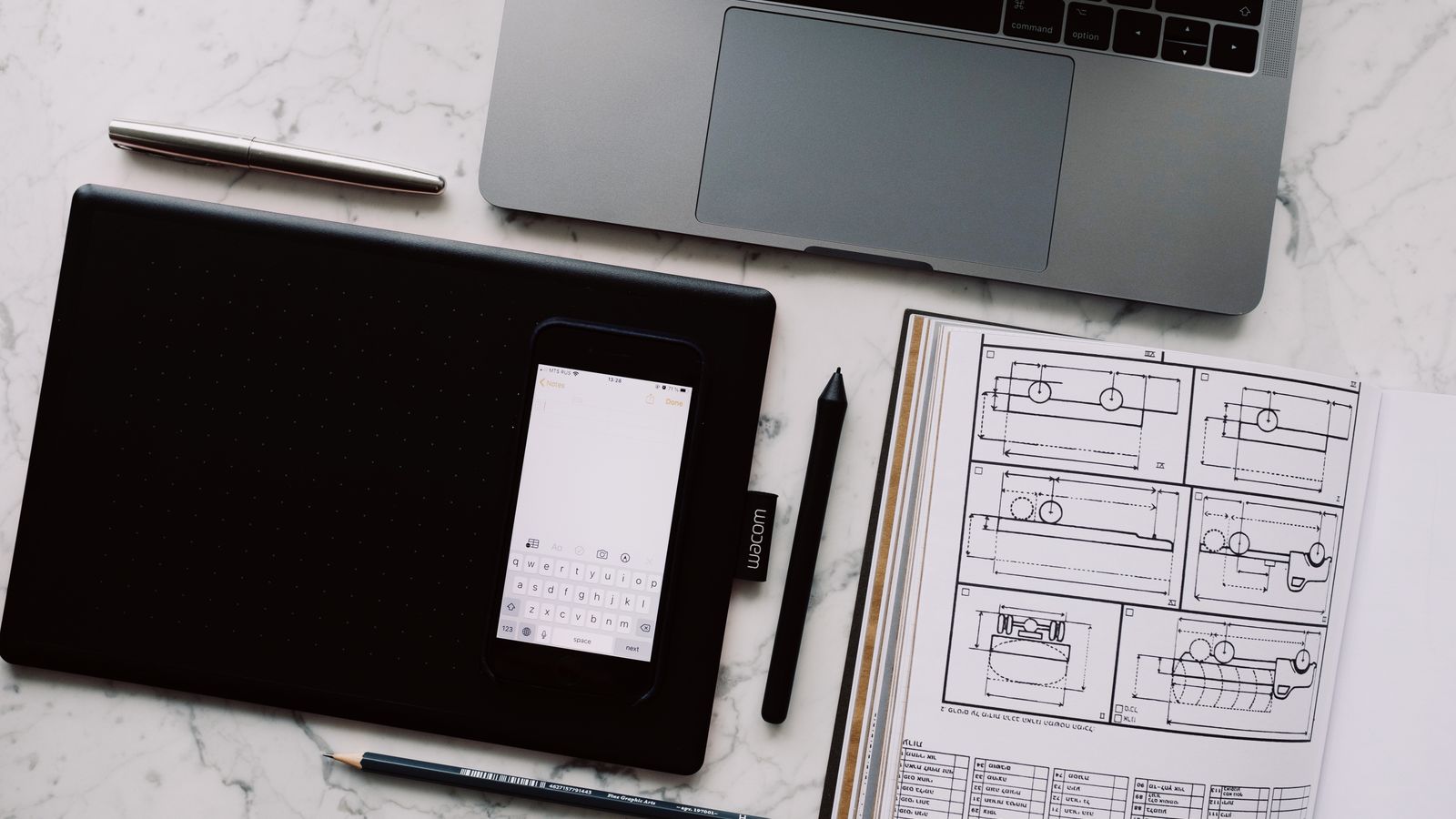 A sketched funding plan beside a phone and laptop