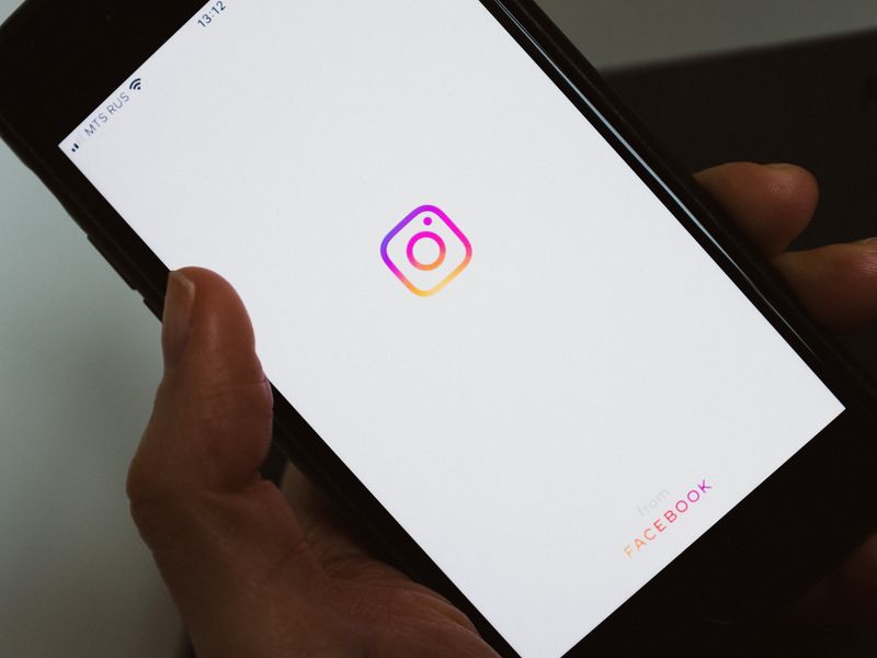 Hand holding a smartphone showing a social media application screen