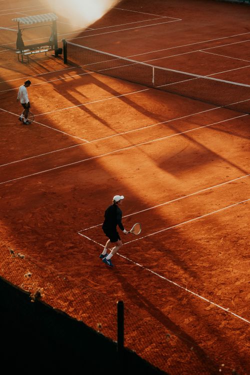 Free Two players compete on a clay tennis court during sunset in Buenos Aires, Argentina. Stock Photo