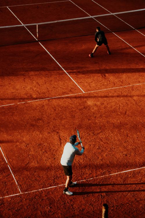 Free Tennis players competing on a sunlit clay court in Buenos Aires, Argentina. Stock Photo