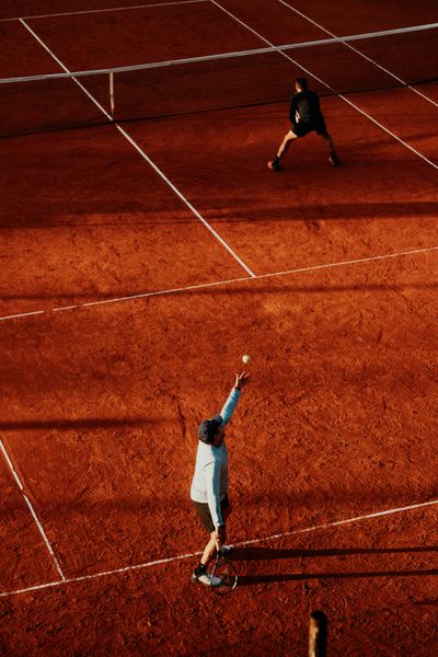 Tennis player serving on a clay court