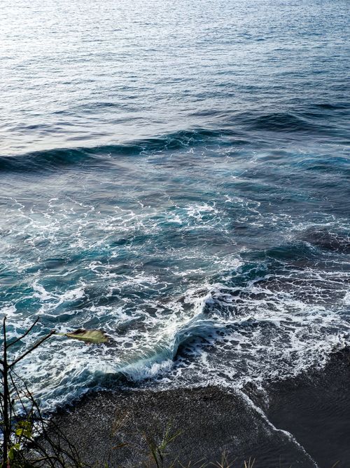 Free Dynamic ocean waves break powerfully on a rocky coastal shore, creating a vivid and dramatic seascape. Stock Photo