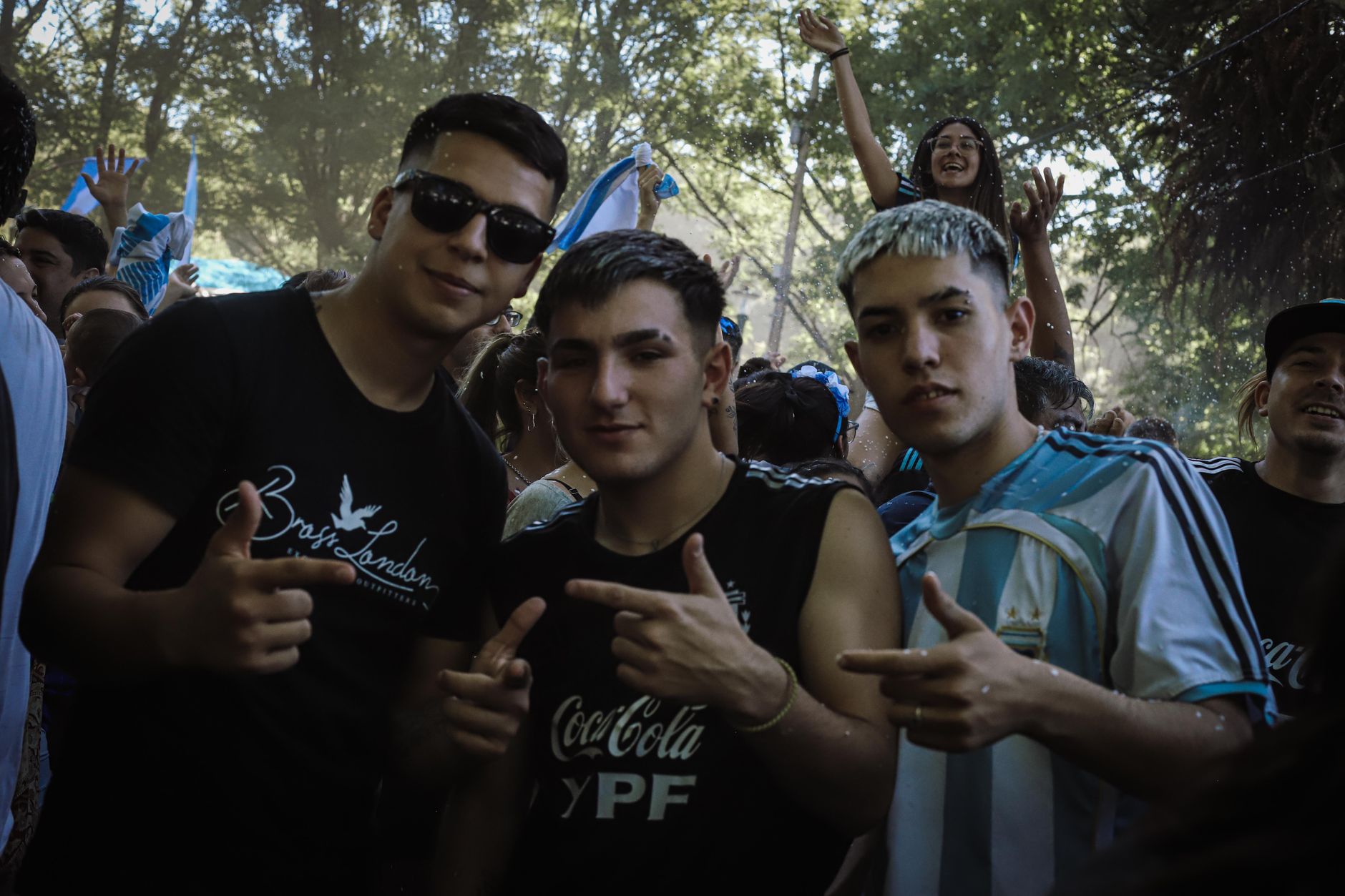 Enthusiastic group celebrating outdoors with Argentine flags in Buenos Aires.
