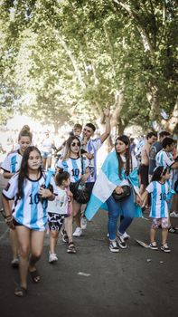Crowd in Buenos Aires celebrating in Argentine jerseys and flag.