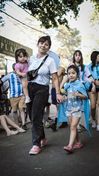 Joyful scene of family celebrating Argentina's World Cup win in Buenos Aires with national colors.