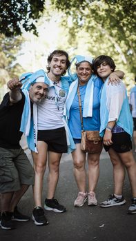Group of four cheerful football fans in Buenos Aires, celebrating outdoors.