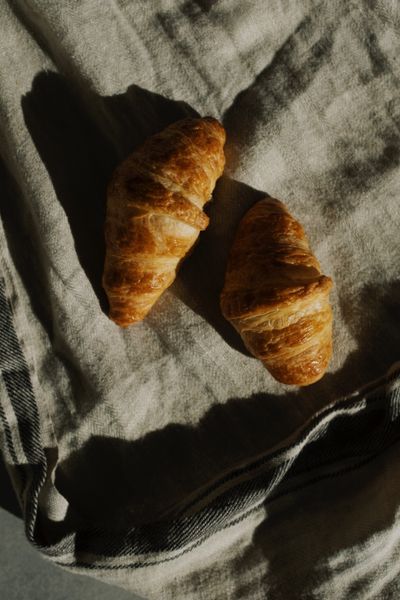 Rustic croissants on textured linen, photo by ready made on Pexels