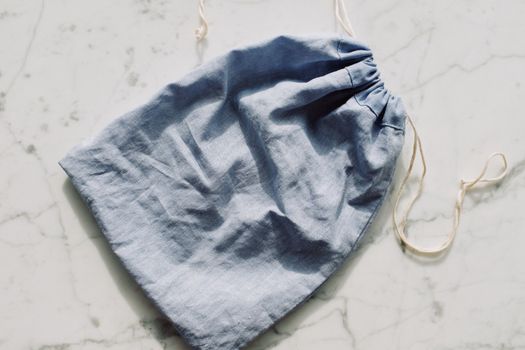 Empty textile blue bag with drawstrings placed on table in light room