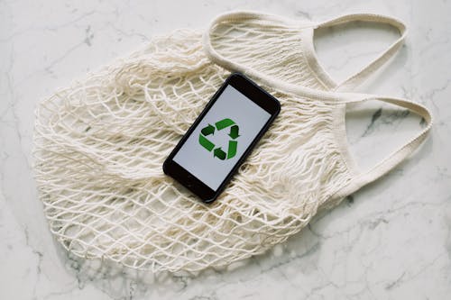 White mesh bag with smartphone placed on white surface in light room