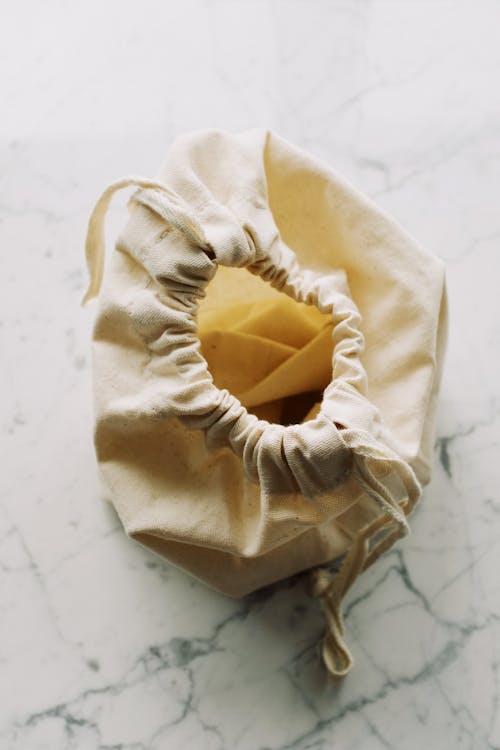 Free From above view of simple cotton zero waste bag with drawstrings placed on marble table in light room Stock Photo