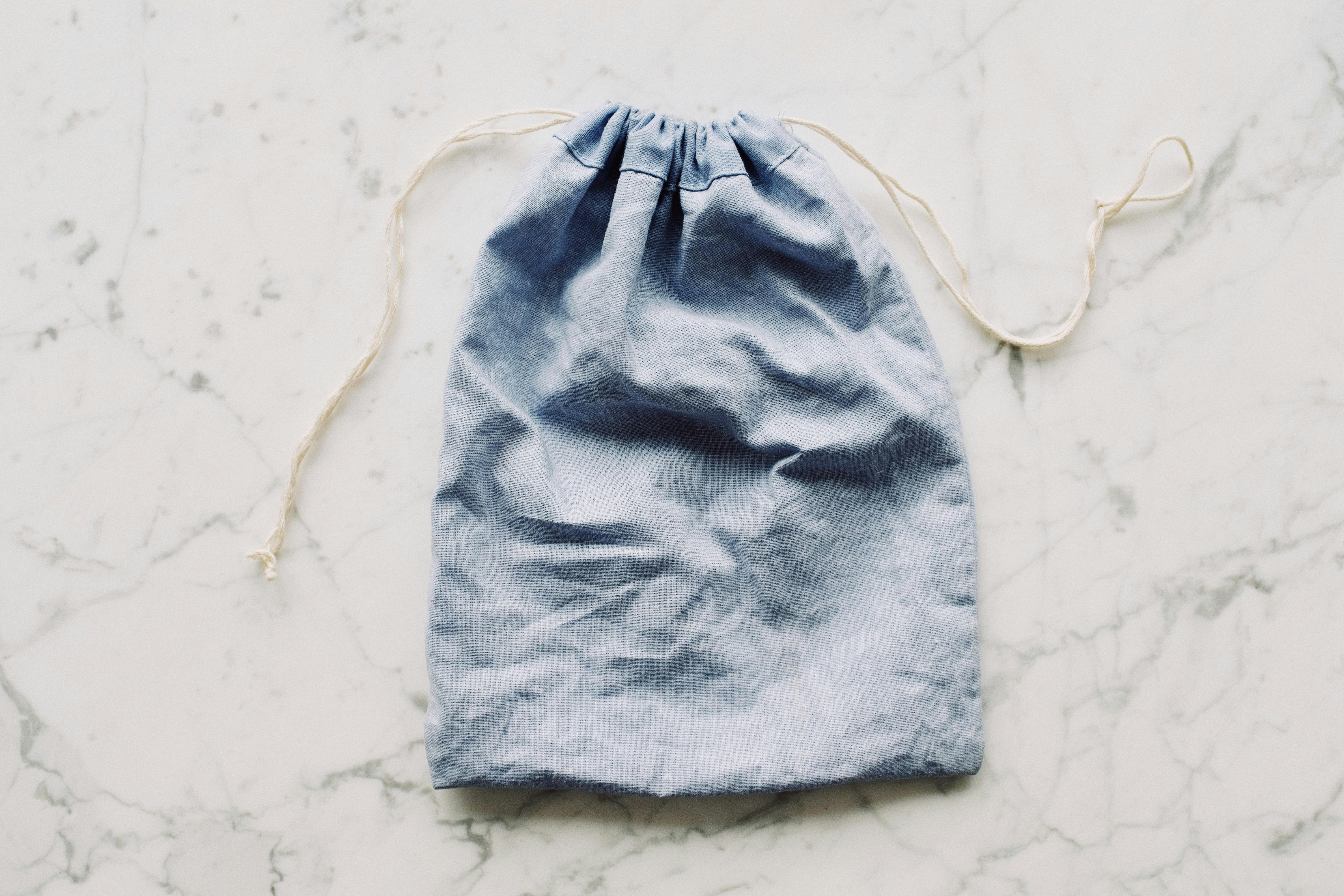 Blue textile bag placed on marble table · Free Stock Photo