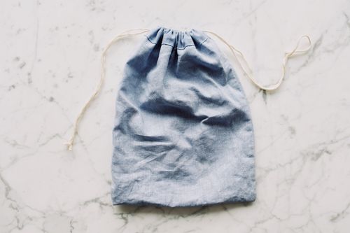 Free Top view of blue empty fabric reusable bag with white drawstrings placed on marble surface in light room Stock Photo