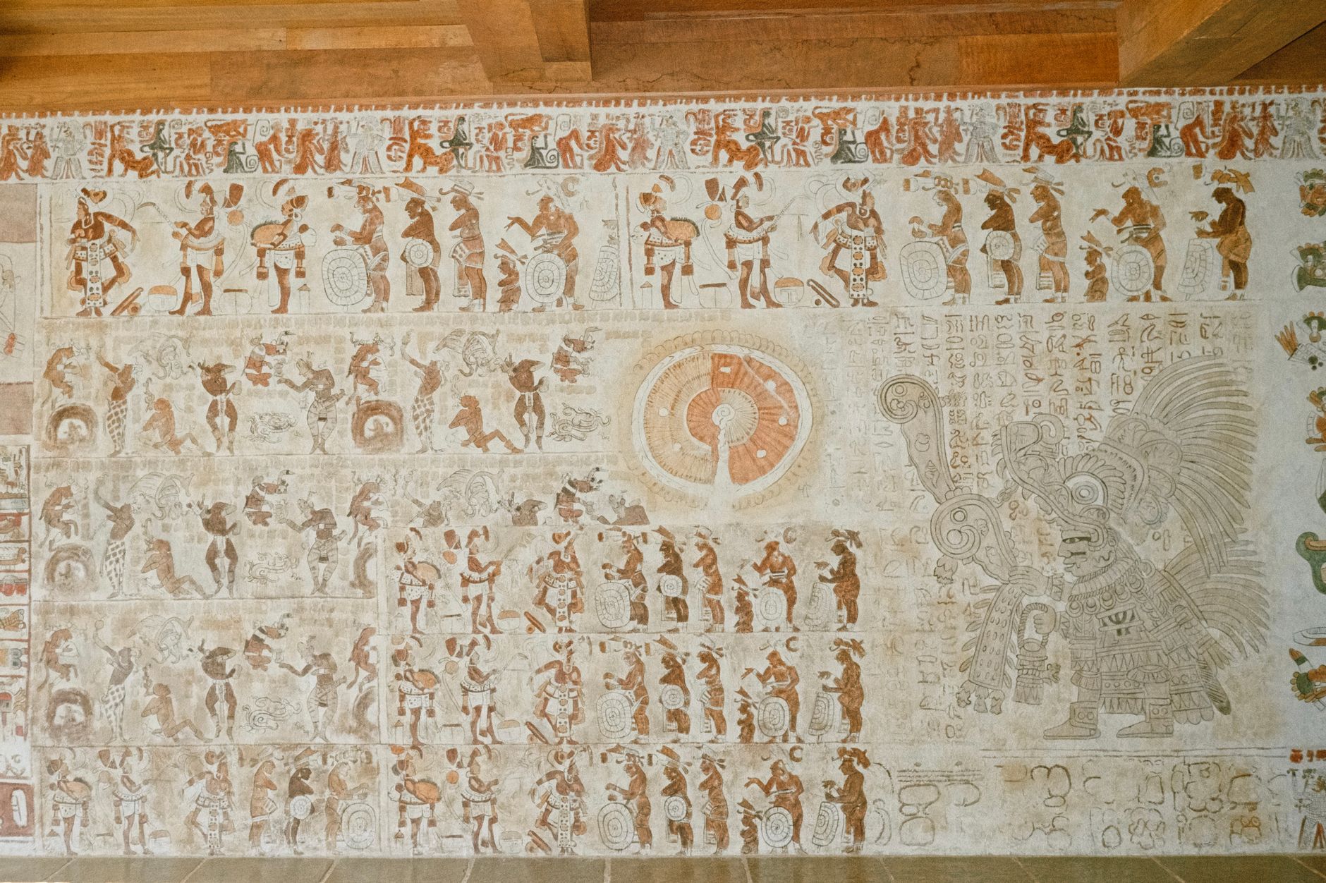 Detailed mural depicting ancient Mayan culture with intricate carvings and symbols, showcasing historical art.