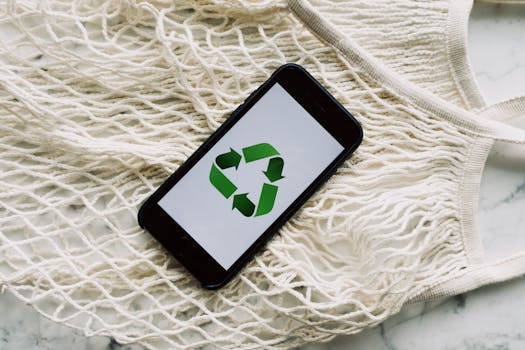 A smartphone displaying a recycle symbol on a mesh bag, emphasizing sustainable consumerism.