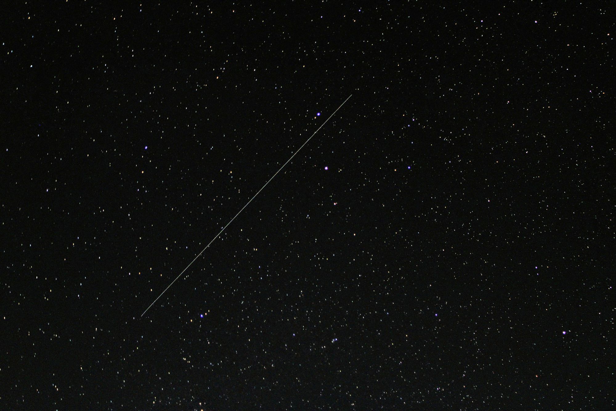Captivating starry night sky with a visible shooting star streaking across the cosmic backdrop.