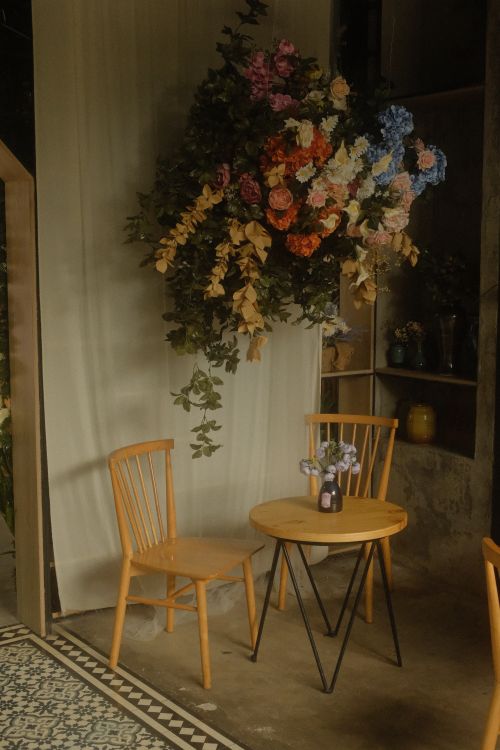 Free Charming vintage cafe interior with floral decor and wooden furniture in Vĩnh Long, Vietnam. Stock Photo