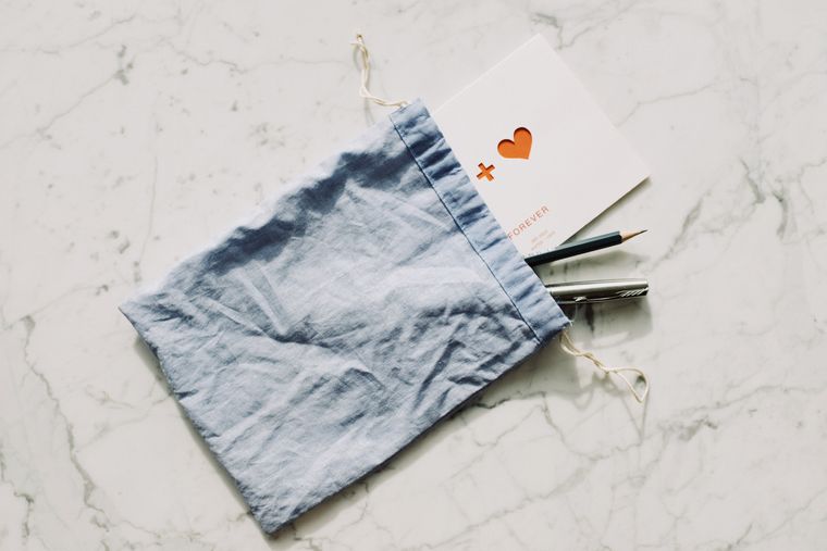 Flat fabric pouch holding pencils and a card on marble - photo by ready made on Pexels