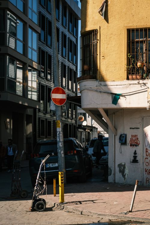 Free Street scene with no entry sign, graffiti, and modern architecture in city. Afternoon lighting casts shadows. Stock Photo