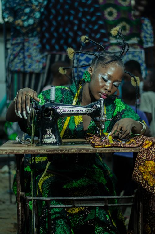 Free A fashion designer works with vibrant African fabric using a vintage sewing machine. Stock Photo