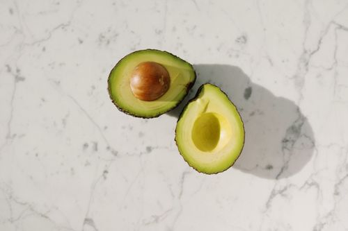 Free High-quality image of fresh avocado halves on a marble surface, perfect for food blogs. Stock Photo