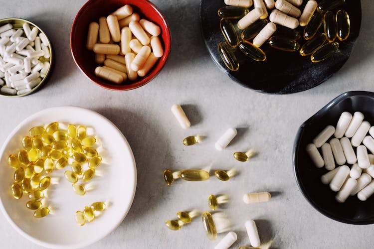 Assorted Vitamins In Different Plates On Table