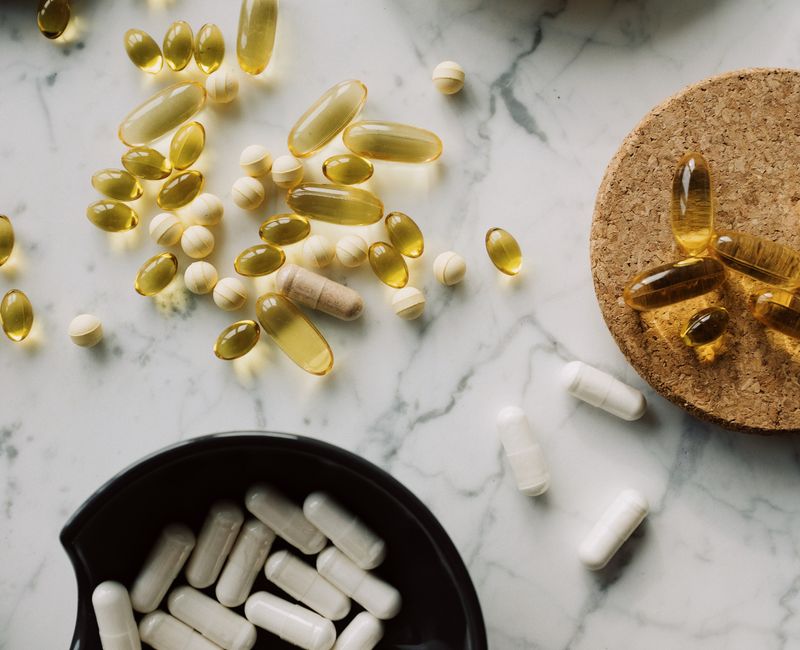 Assorted dietary supplements including vitamins and minerals on a kitchen table.