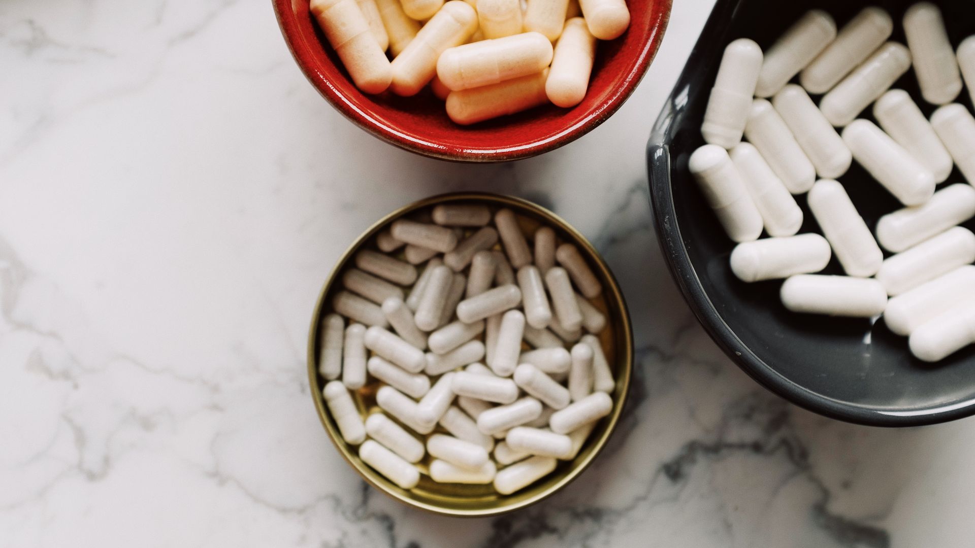 Can Modafinil Be Crushed or Split? Answering Your Questions Top view of various capsules in bowls placed on a marble surface, emphasizing healthcare and medication themes — can modafinil be crushed or split