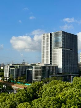 Aerial view of contemporary office buildings in Shanghai against a vibrant blue sky.