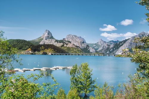 Free Idyllic landscape of Riaño Reservoir with mountains and clear blue skies in León, Spain. Stock Photo