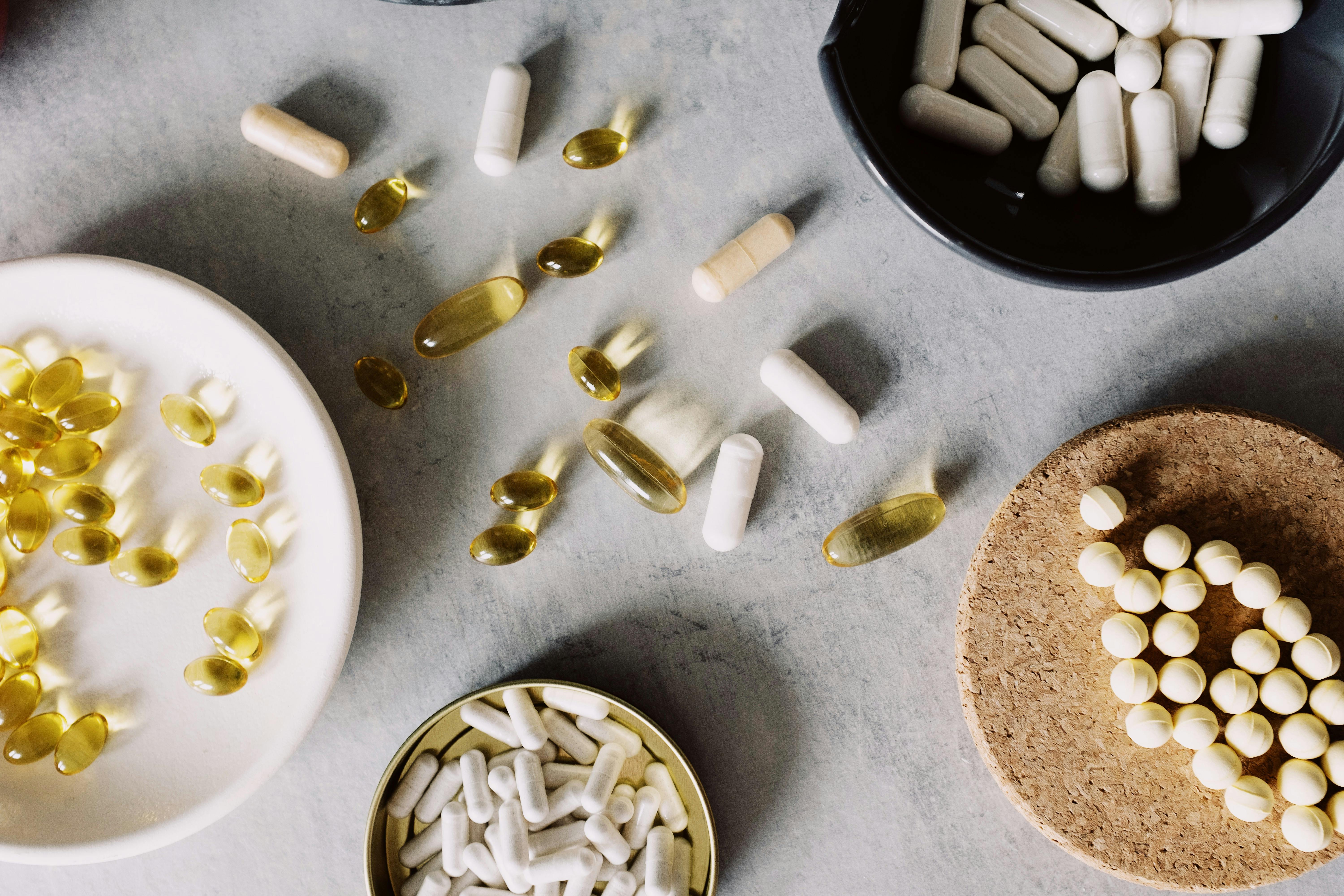 assorted vitamins placed in diverse utensil on gray board