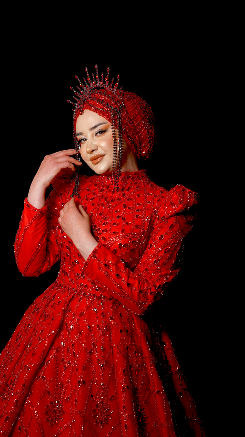 Free A beautiful woman in a stunning red beaded dress and decorative crown posing elegantly. Stock Photo