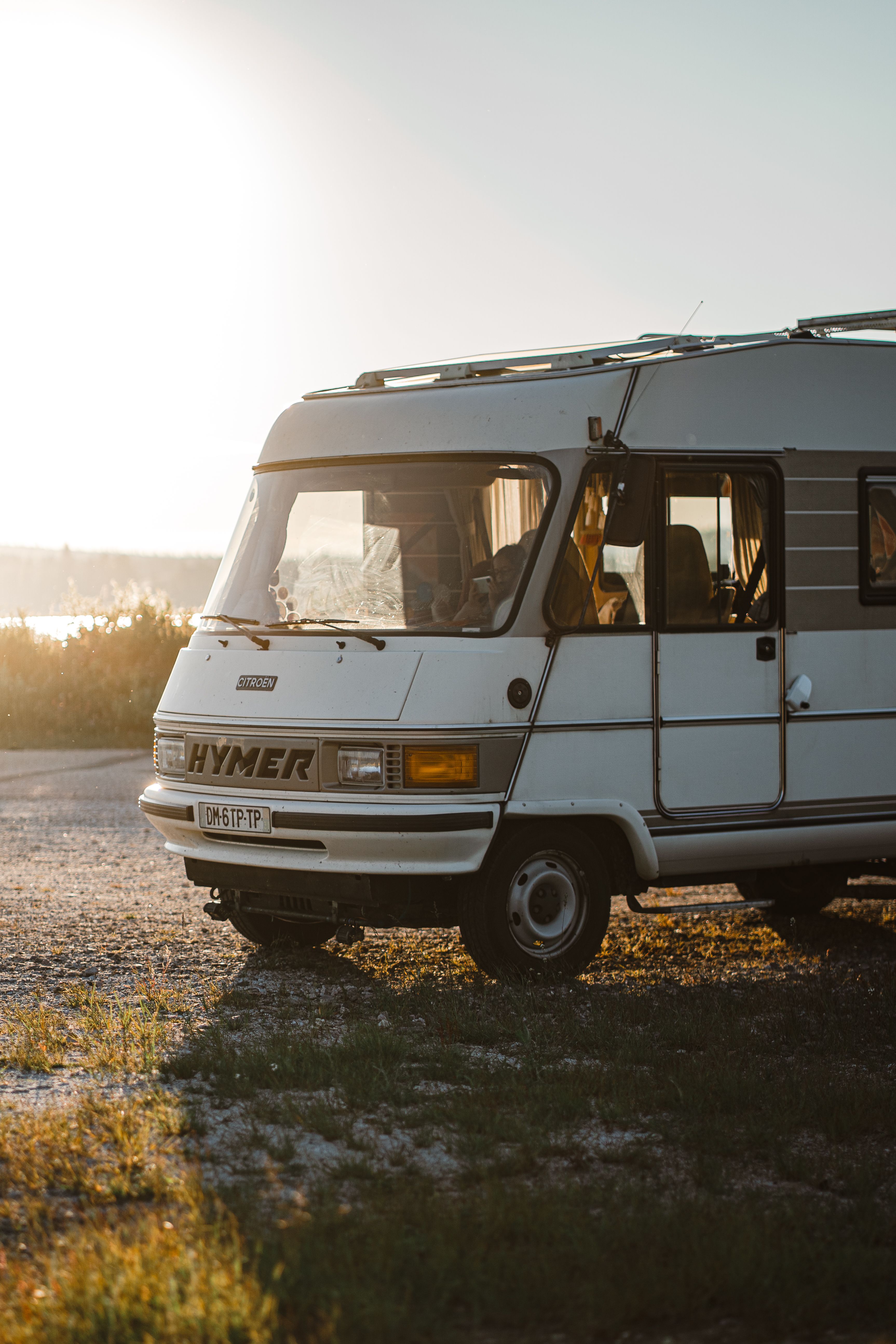 Vintage Hymer motorhome parked outdoors during sunrise, perfect for road trip and travel enthusiasts.