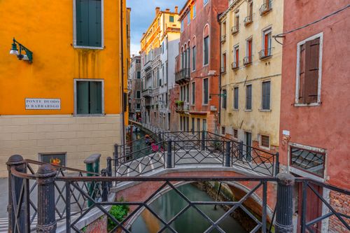 Free Captivating view of a Venetian canal and colorful buildings at sunrise. Stock Photo