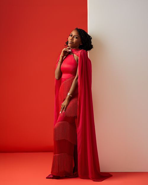 Free Stylish woman posing in a red dress against a modern minimalist background. Stock Photo