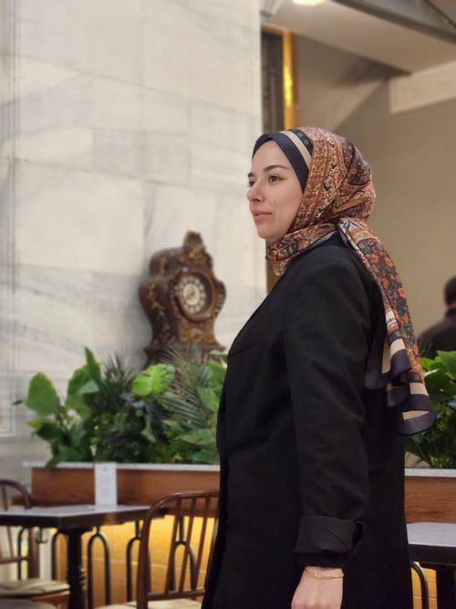 Free Elegant woman in a hijab at a vintage café setting, side view. Stock Photo