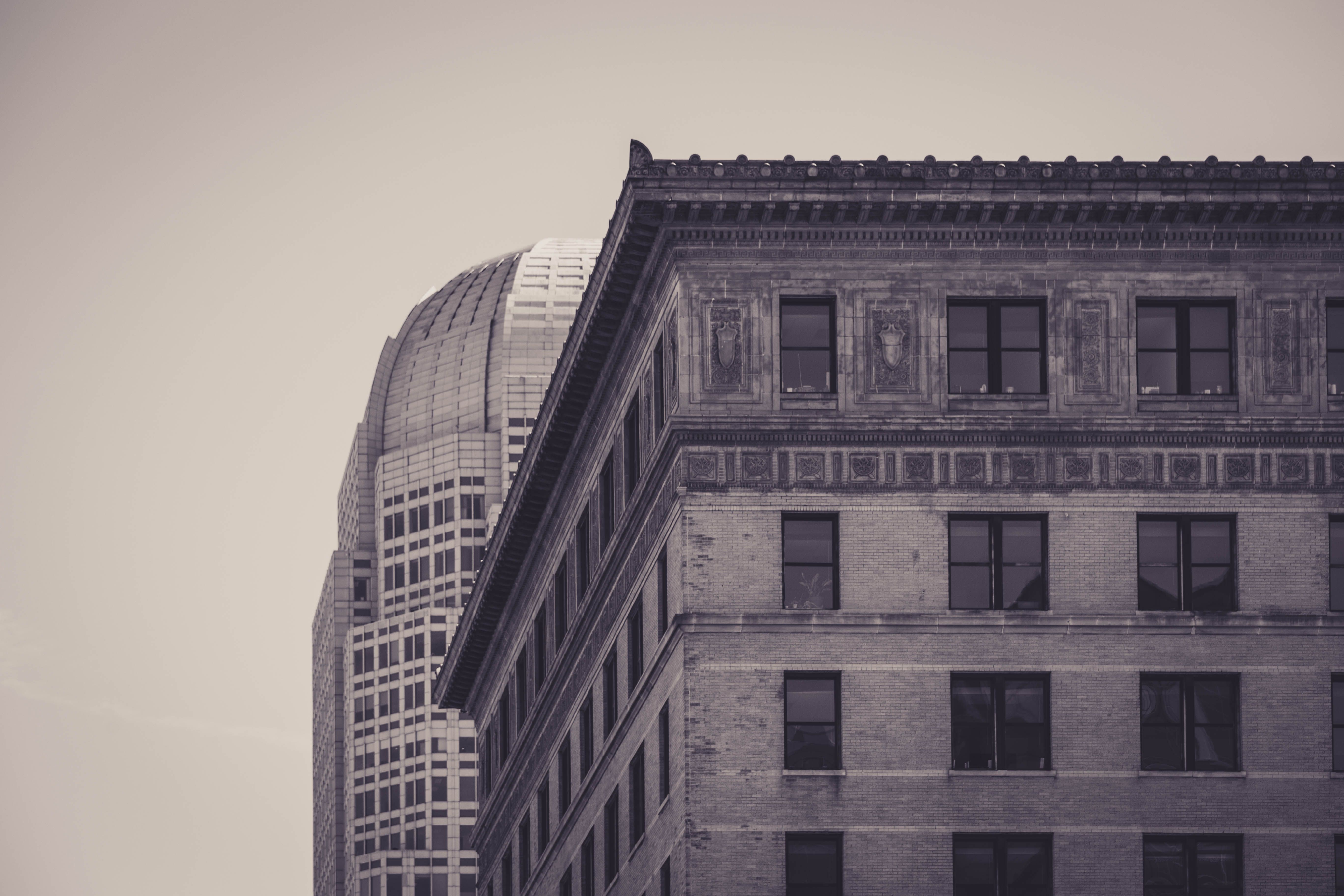 A sepia-toned photograph showcasing the contrast between historical and modern urban architecture.