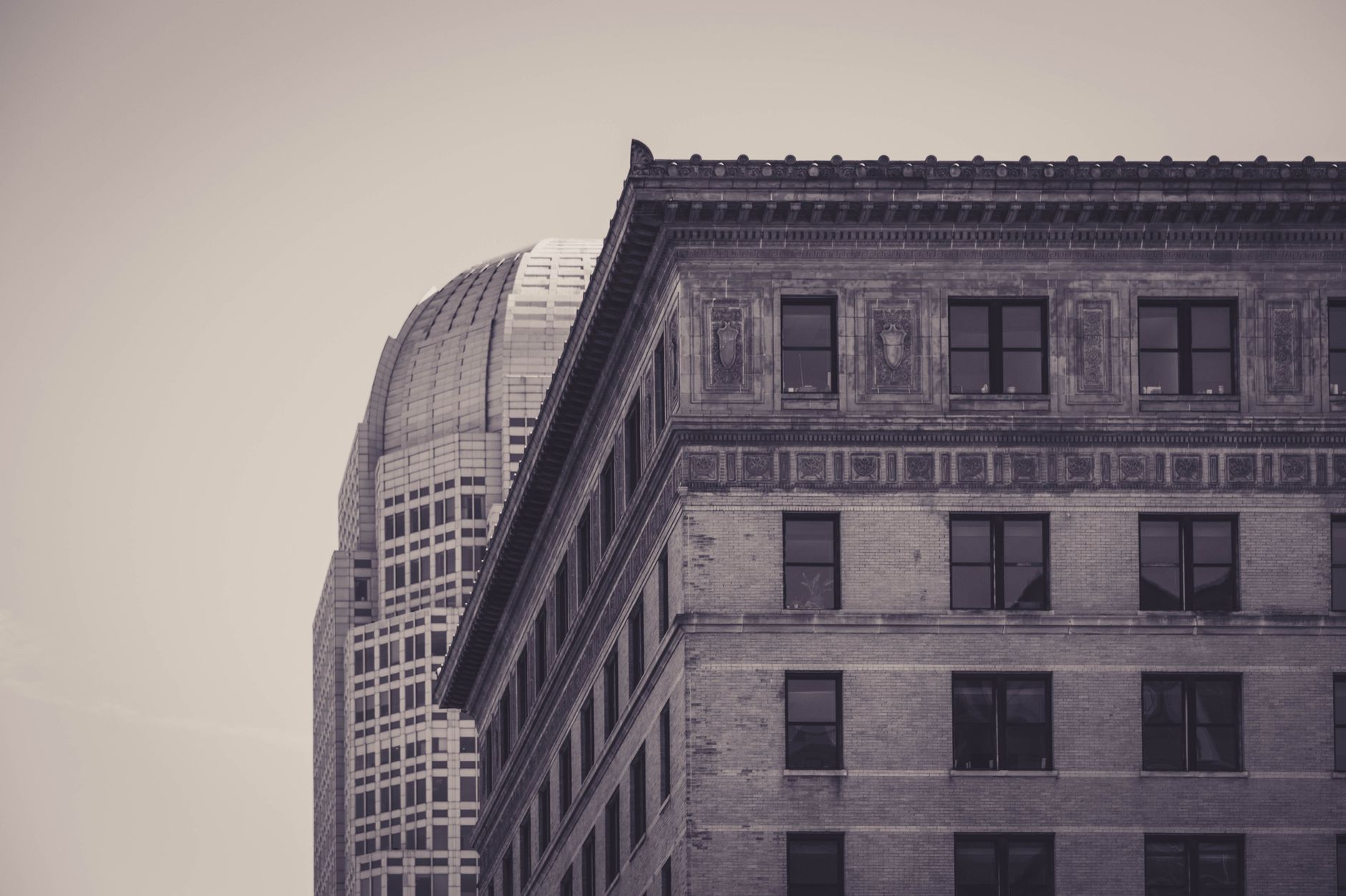 A sepia-toned photograph showcasing the contrast between historical and modern urban architecture.