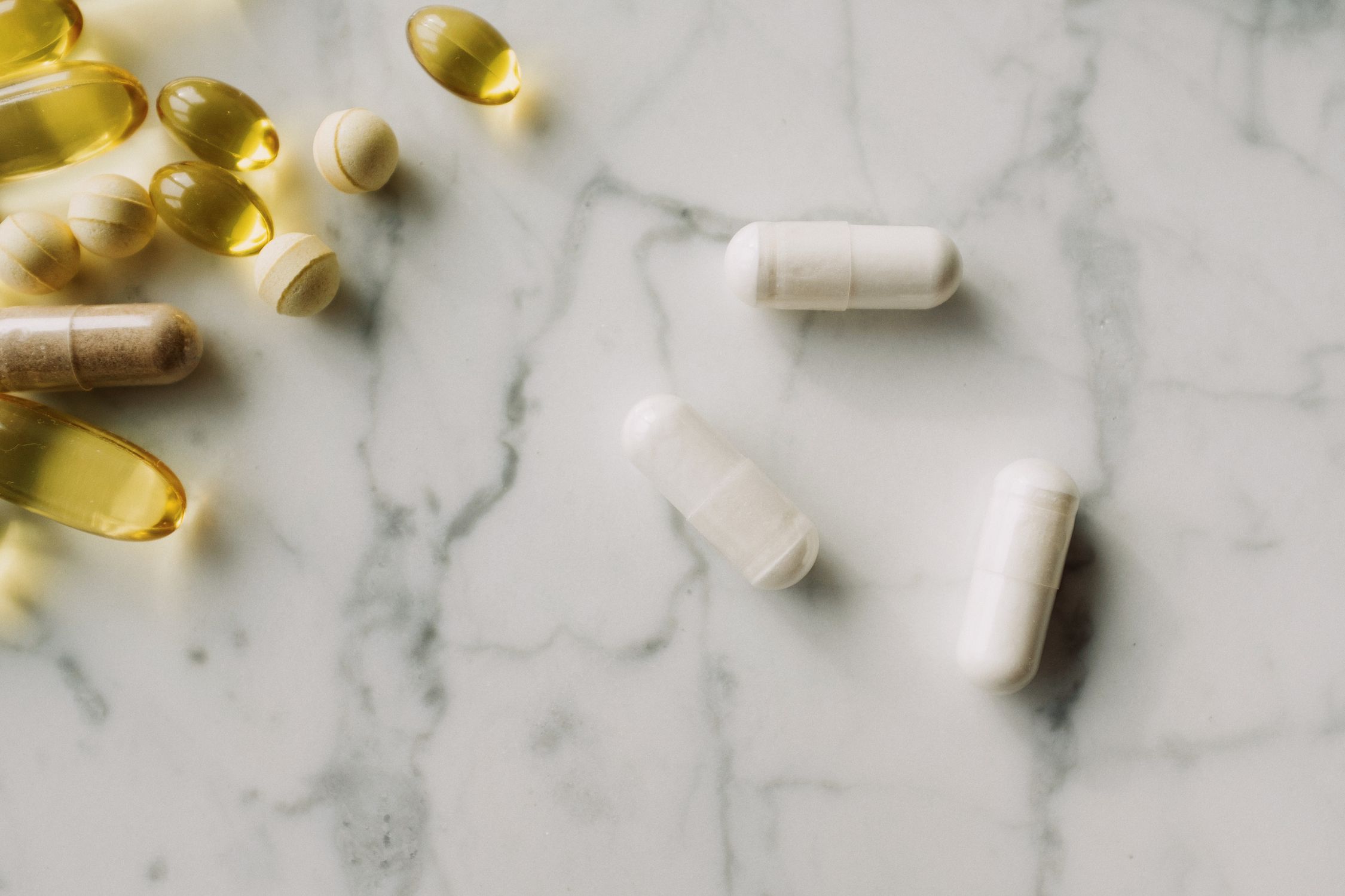 Pílulas e suplementos representando a vulnerabilidade nutricional e hormonal individual