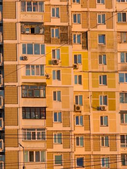 Sunset light casts a warm glow on the facade of an urban apartment building.